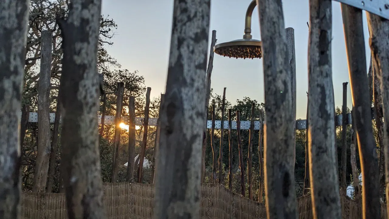 The outdoor shower in a wooden enclosure at sunset
