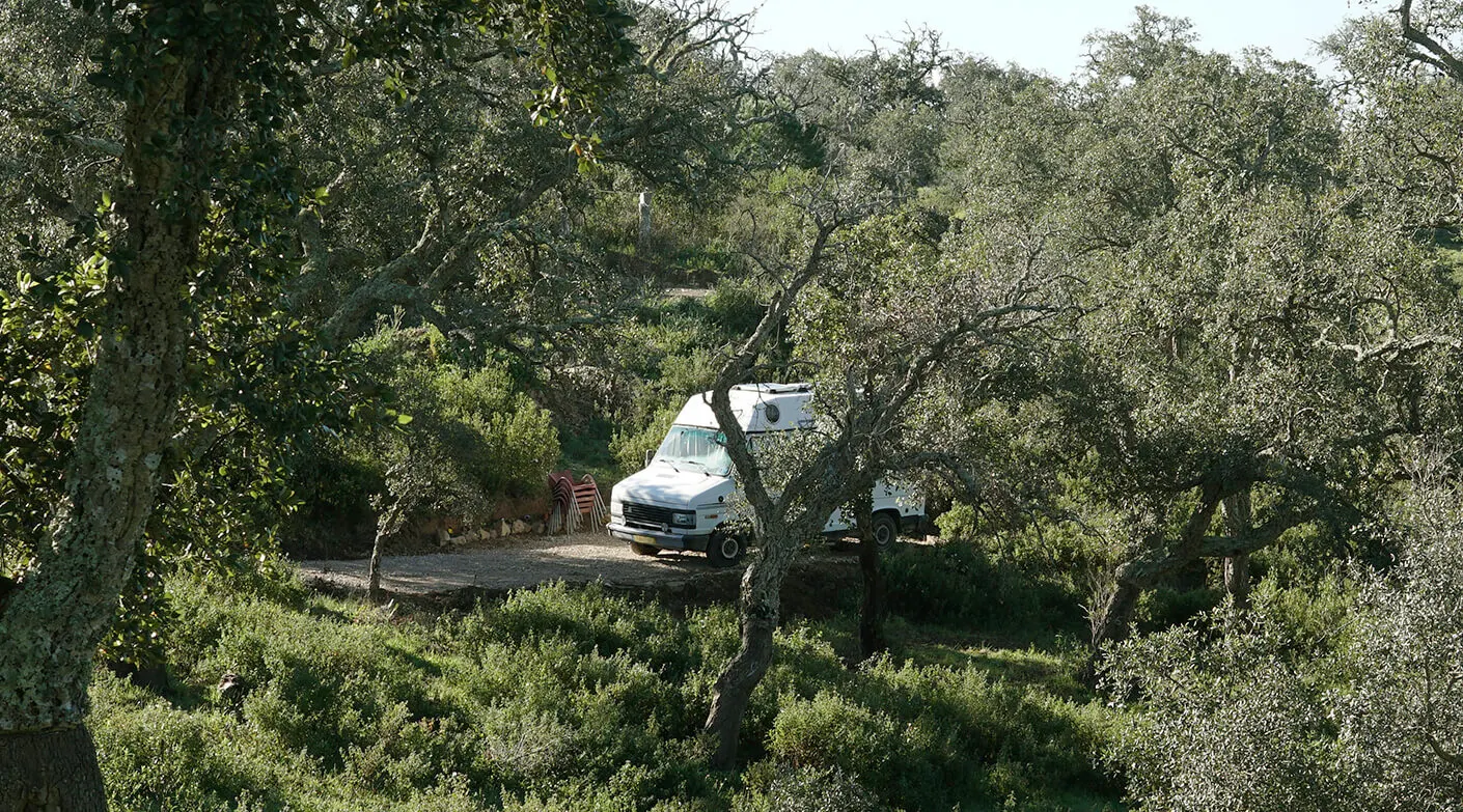 A camper van parked in its own spot among the cork oaks